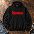 Black Thundercunts hoodie with red slogan lettering, laid flat on wooden floorboards.