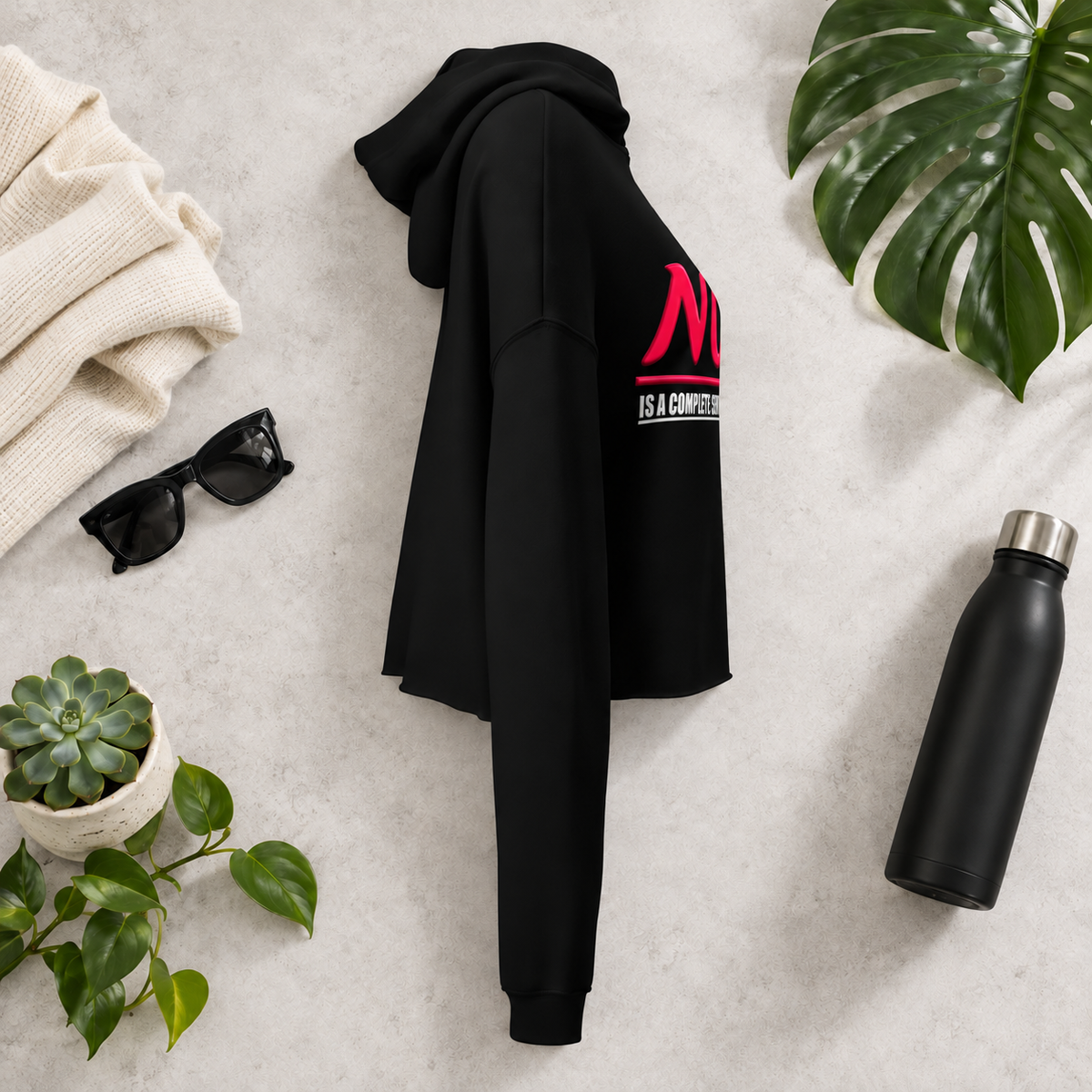 Black women’s cropped hoodie with glossy pink “NO.” lettering and white “IS A COMPLETE SENTENCE.” slogan.