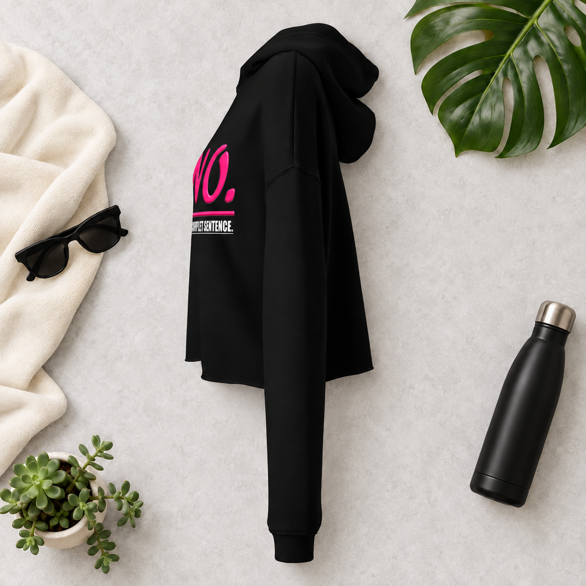 Black women’s cropped hoodie with glossy pink “NO.” lettering and white “IS A COMPLETE SENTENCE.” slogan.