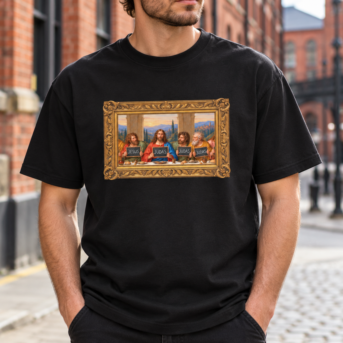 Black box tee featuring The Original Round Table Last Supper parody in an ornate gold frame, with JESUS and JUDAS voting boards.