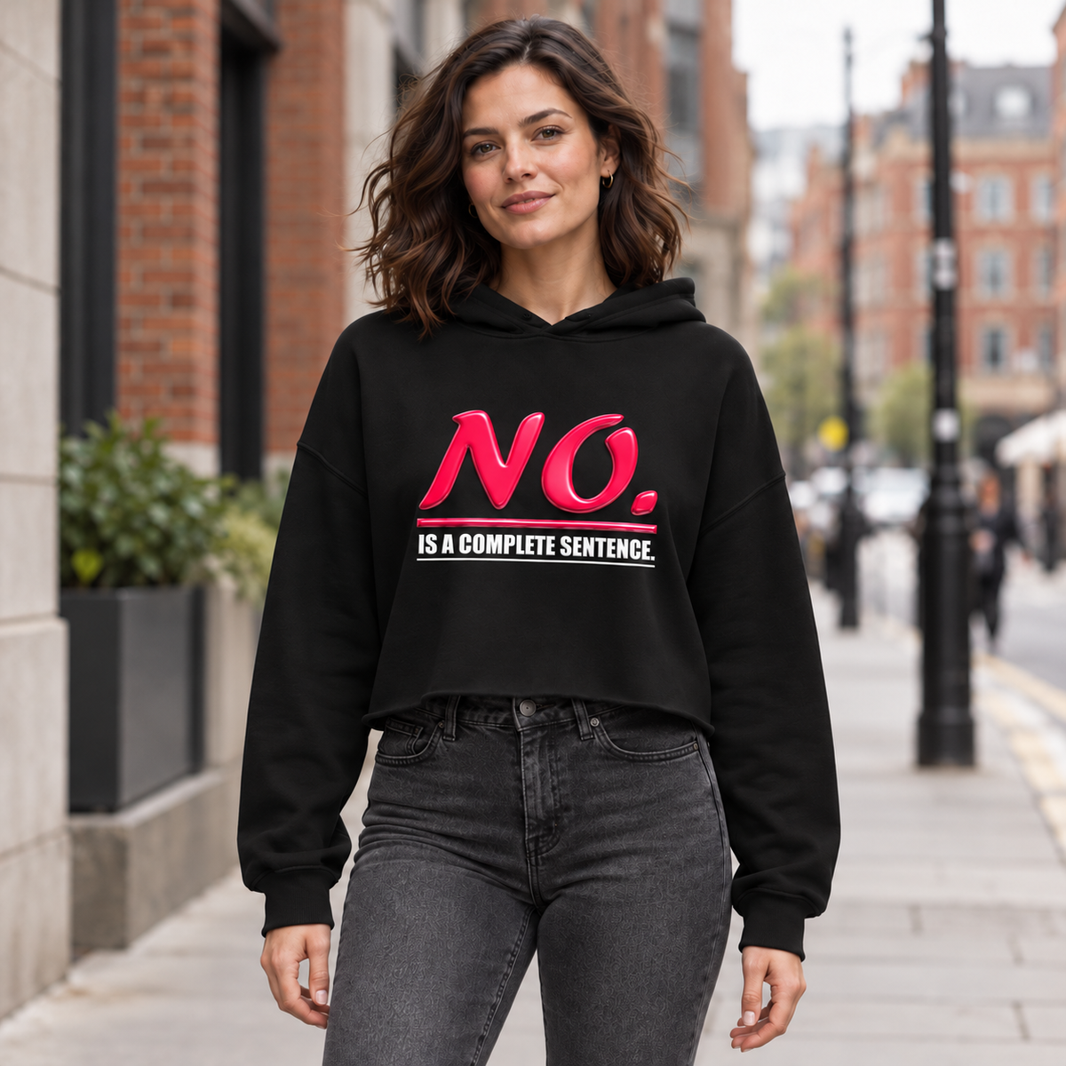 Black women’s cropped hoodie with glossy pink “NO.” lettering and white “IS A COMPLETE SENTENCE.” slogan.