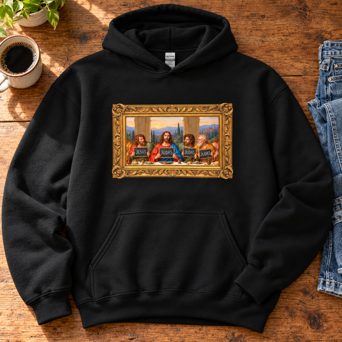 Unisex hoodie featuring The Original Round Table Last Supper parody in a gold frame, with JESUS and JUDAS chalkboards.