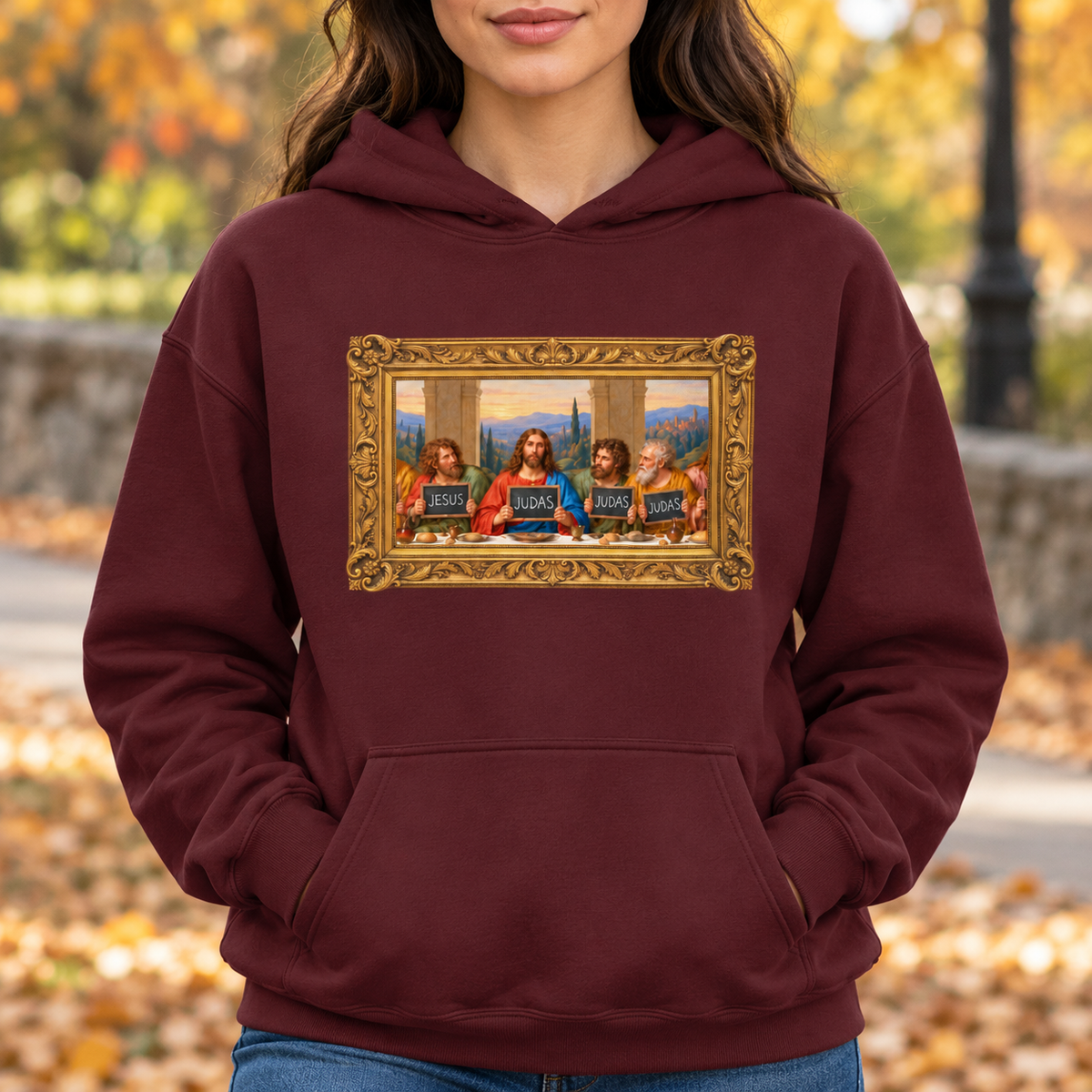 Maroon hoodie featuring The Original Round Table Last Supper parody in a gold frame, with JESUS and JUDAS chalkboards.